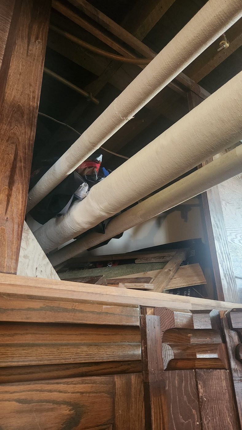The open storage space above the stage, with insulated water pipes running through it, before the build