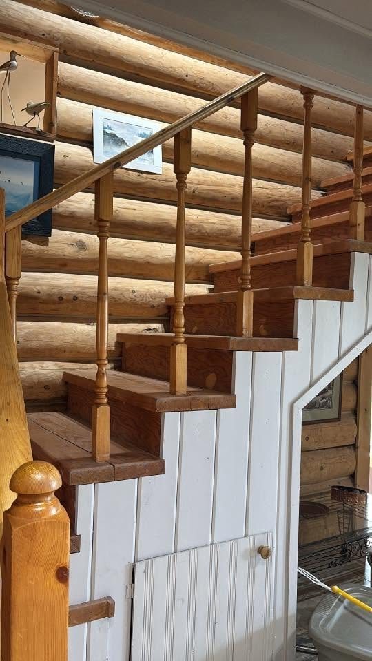 Log-home staircase with turned railings, built by Staged Right Carpentry
