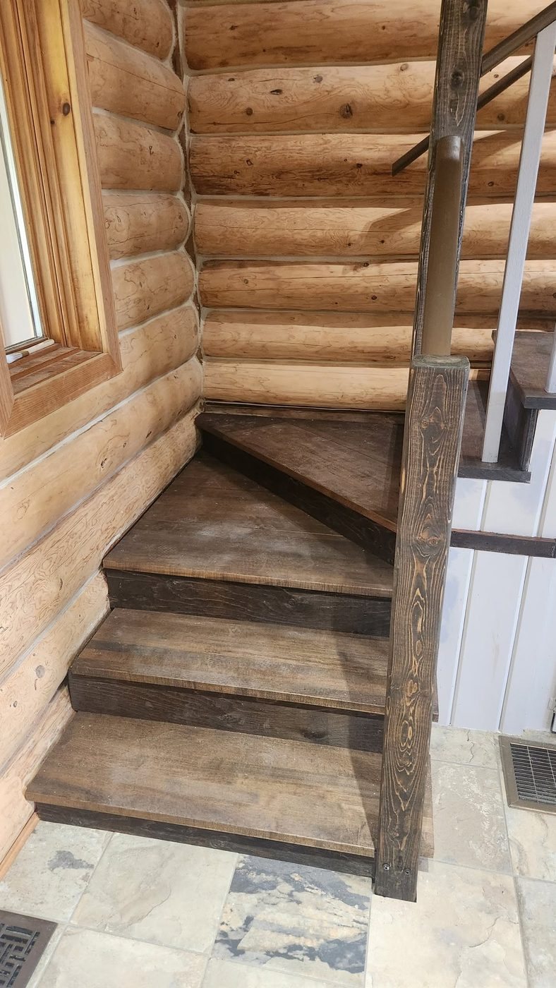 Log-home staircase and landing with wood railings, built by Staged Right Carpentry
