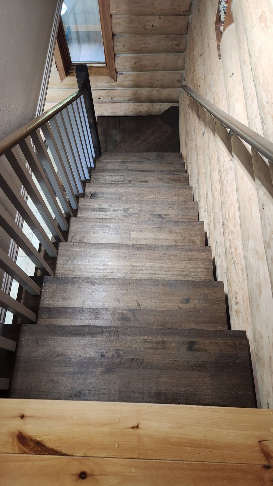 Log-home staircase seen from the top landing, built by Staged Right Carpentry